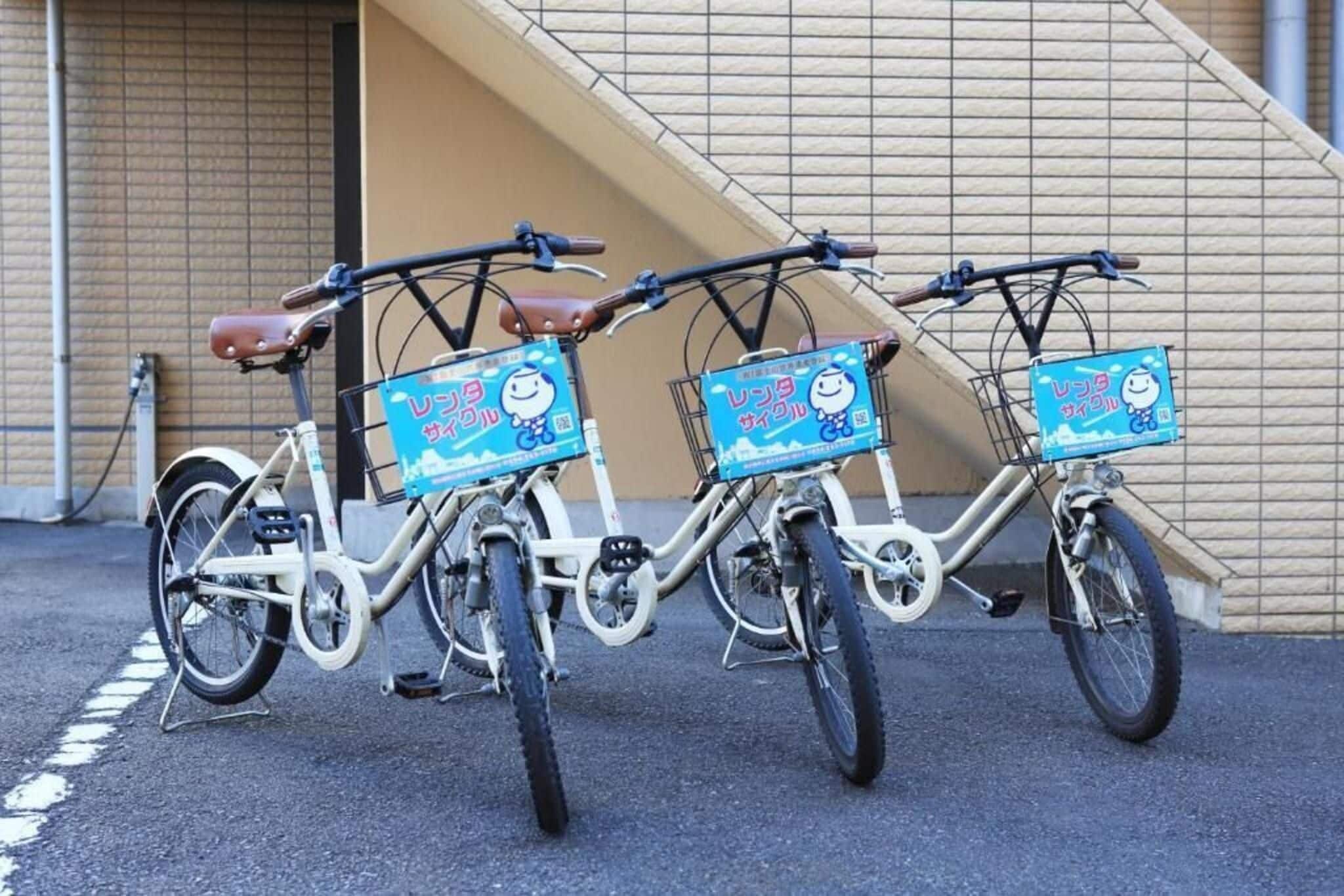 Three bicycles parked in front of a building with a ramp.