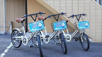 Three bicycles parked in front of a building with a ramp.