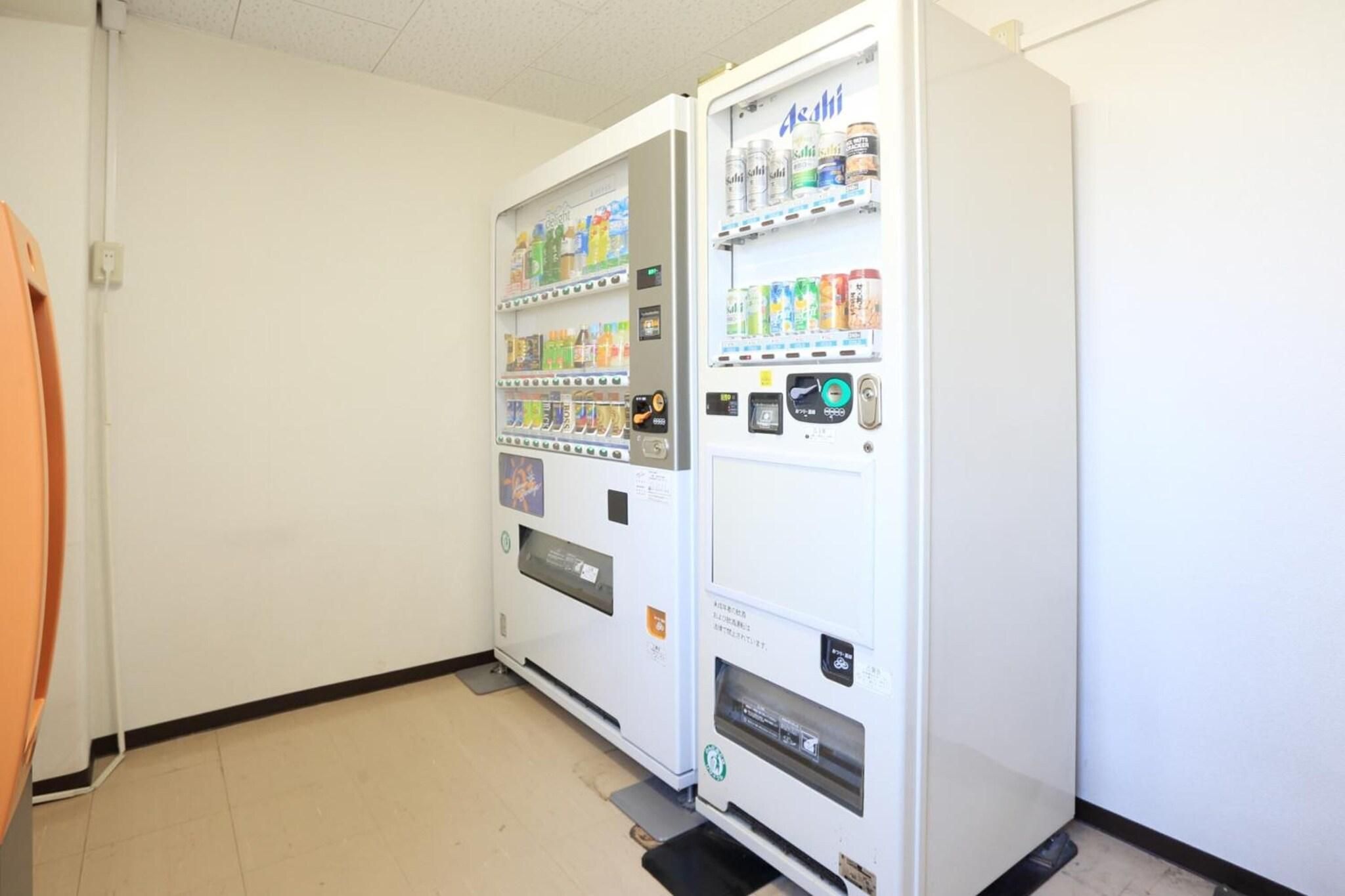 A vending machine with various drinks and snacks, a door, and a tiled floor.