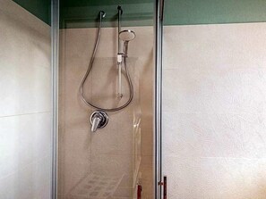 Una ducha con cabezal de ducha manual y grifo empotrado.
