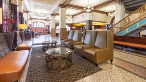 A lobby with leather sofas, a staircase, and a chandelier. - Drury Inn Union Station (St. Louis)