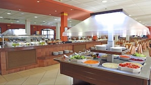 Un buffet con diversi cibi e una grande cappa industriale.
