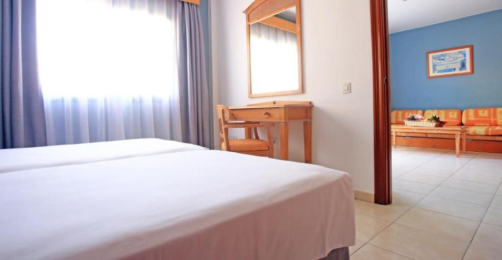 Ein Hotelzimmer mit Bett, Schreibtisch, Stuhl und Sofa.