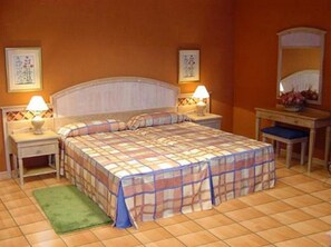 Ein Hotelzimmer mit einem Bett, zwei Nachttischen, einem Teppich in Grün und einem Spiegel.