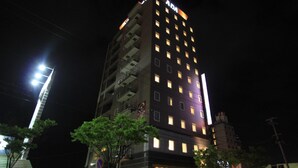 A multi-story building with illuminated windows and a sign that reads 'ADA' at the top.