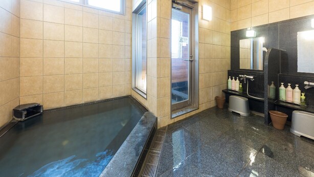 A modern bathroom with a large bathtub, a shower area, and a vanity with toiletries.