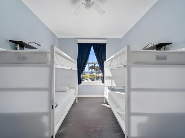 A hotel room with bunk beds, a ceiling fan, and a window with curtains. - Venice Beach Cotel (Venice)