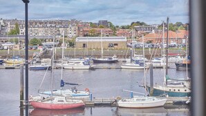 A marina with multiple boats docked, a building in the background, and a clear sky. - Host & Stay | Paylors View Cottage (Whitby)