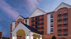 Un hotel de varios pisos con una entrada destacada y balcones.