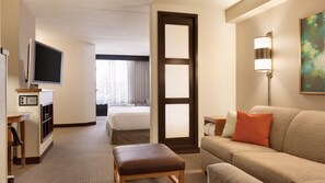 A hotel room with a bed, a sofa, a TV, a desk, and a lamp. - Sonesta Select Tucson Airport (Tucson)