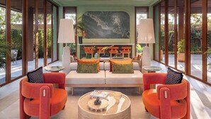 A modern living room with a large painting, two sofas, a coffee table, and a glass ceiling. - Luxury 2BR Pool Apartment in Bang Tao Phuket (Choeng Thale)
