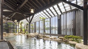 A covered outdoor pool with a wooden deck, large windows, and a view of the surrounding area. - Taoya Nachikatsuura (Nachikatsuura)