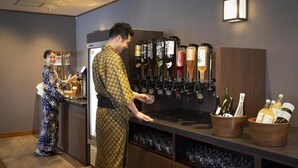 A bar area with a wine dispenser and a counter where a person is pouring a drink. - Taoya Nachikatsuura (Nachikatsuura)