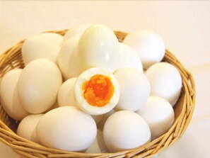 Una cesta con huevos duros, uno de ellos cortado para mostrar la yema.