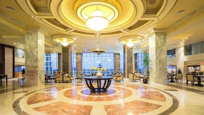A lobby with a marble floor, large chandeliers, and a central seating area. - Sunrise Alora (Hurghada)