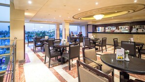 A hotel lobby with multiple seating areas, a bar, and a view of the cityscape. - Sunrise Alora (Hurghada)