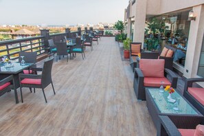 A rooftop terrace with outdoor seating, a glass table, and potted plants. - Gravity Hotel Aqua Park Hurghada (Hurghada)