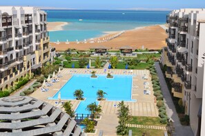 A hotel with a central swimming pool, a beach, and a view of the sea. - Gravity Hotel Aqua Park Hurghada (Hurghada)