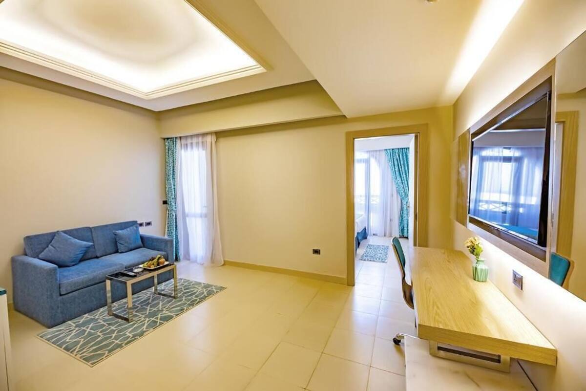 Una sala de estar moderna con un sofá, una mesa de centro, televisor y un comedor.