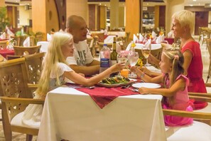 A dining area with tables set for a meal, including plates, cutlery, and beverages. - Gravity Hotel Aqua Park Hurghada (Hurghada)