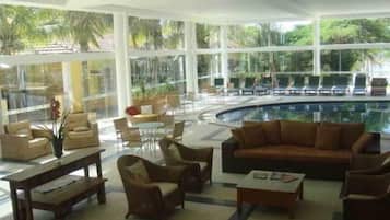 Amplo espaço interno com piscina, espreguiçadeiras e áreas de estar.