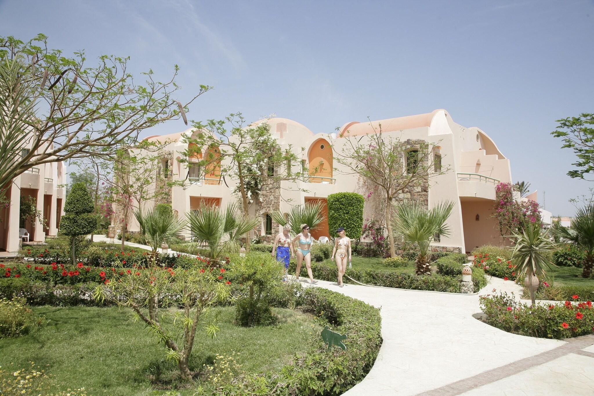 Un resort con varias construcciones, un camino central y jardines bien cuidados.