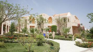 Un resort con varias construcciones, un camino central y jardines bien cuidados.