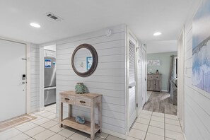 A hallway with a wooden console table, a mirror, and a refrigerator. - ☀️Ground Floor | Golf Cart | Walk to Beach | Seascape 10E⛱️ (Miramar Beach)