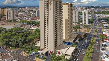 A high-rise building with a central entrance, surrounded by roads and other buildings.