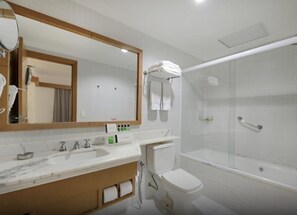 Une salle de bain moderne avec un grand miroir, un lavabo, des toilettes et une douche à parois de verre.