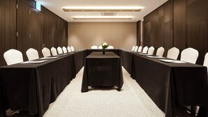 A conference room with a long table, white chairs, and a carpeted floor. - Nine Tree Premier Hotel Myeongdong2 (Seoul)