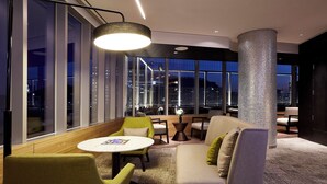 A modern lounge with a sofa, chairs, a round table, and a large pillar. - Nine Tree Premier Hotel Myeongdong2 (Seoul)