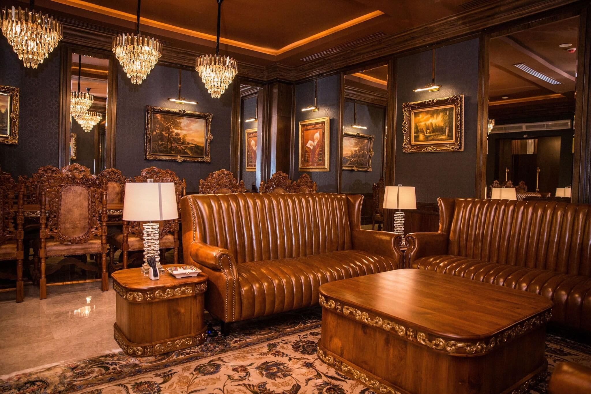 Una habitación lujosa con muebles ornamentados, candelabros y obras de arte enmarcadas en las paredes.