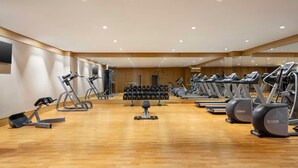 A gym with treadmills, elliptical machines, and free weights. - Levatio Hotel (Muscat)