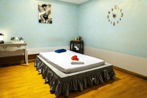 A bedroom with a bed, a dresser, a nightstand, a wall clock, and a painting. - Levatio Hotel (Muscat)