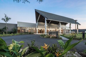 A modern hotel with a covered entrance, a signboard, and a landscaped garden. - Pullman Nadi Bay Resort and Spa Fiji (Nadi)