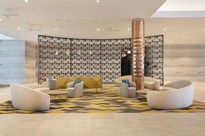 A modern lobby with a geometric patterned wall, a central column, and contemporary seating. - Pullman Nadi Bay Resort and Spa Fiji (Nadi)