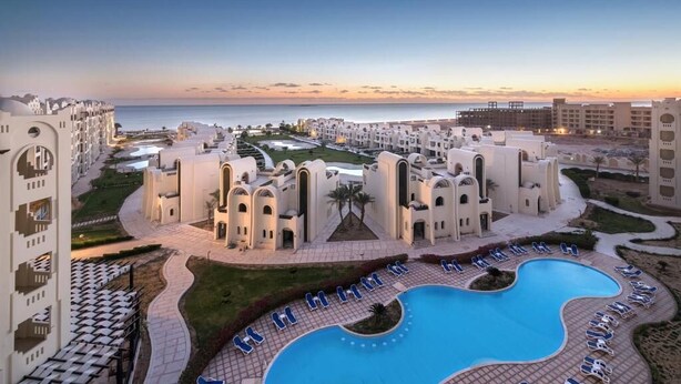Ein Resort mit Pool, mehreren Gebäuden und Blick aufs Meer.