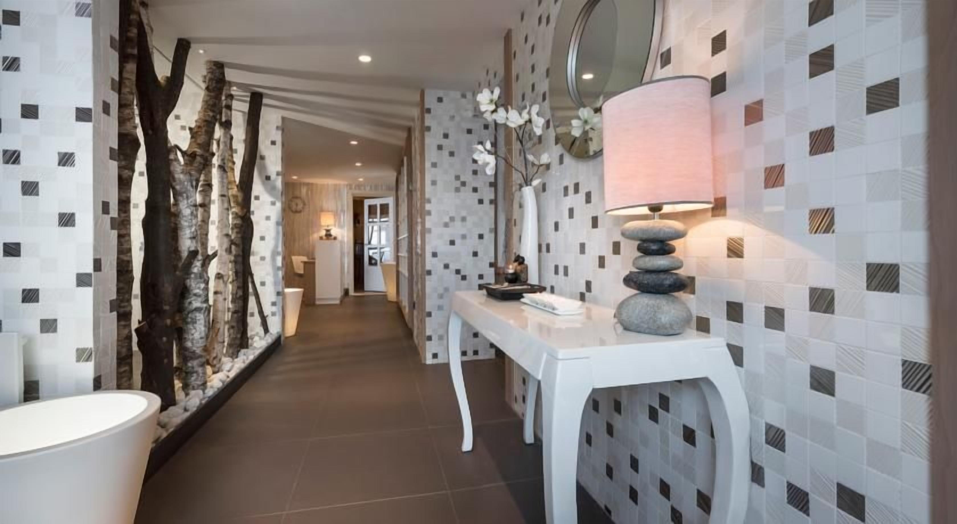 A hallway with a white console table, a lamp, and a decorative rock stack.