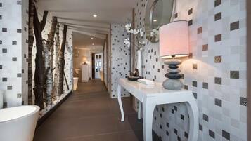A hallway with a white console table, a lamp, and a decorative rock stack.