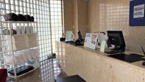A hotel reception desk with a computer, a small table, and a signboard. - Reiah Hotel Kusatsu (Kusatsu)