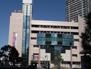 A multi-story building with a modern architectural design, featuring large glass windows and a flat roof. - Reiah Hotel Kusatsu (Kusatsu)