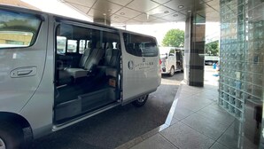 A white van parked inside a building with a tiled floor and a glass wall. - Reiah Hotel Kusatsu (Kusatsu)
