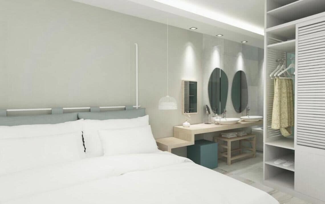 Un dormitorio moderno con una cama grande, mesitas de noche, un escritorio y un vestidor con ropa colgada.