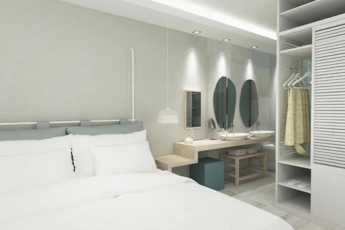 Ein modernes Schlafzimmer mit einem großen Bett, Nachttischen, einem Schreibtisch und einem begehbaren Kleiderschrank mit Kleidung.