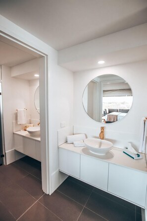 A modern bathroom with a large mirror, two sinks, and a walk-in shower. - Discovery Holiday Parks - Rottnest Island (Perth)