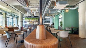 A modern interior with a central seating area, tables, chairs, and a bar area with shelves. - Hendrick Smithfield (Dublin)