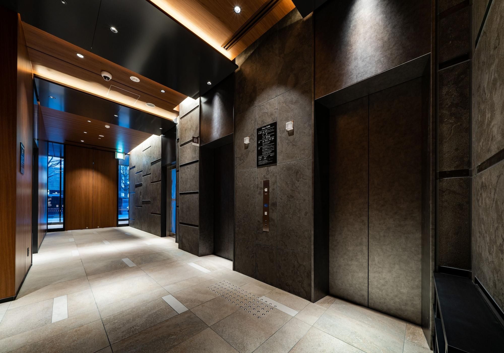 A modern elevator interior with a digital display, a wall-mounted sign, and a tactile floor path for visually impaired individuals.