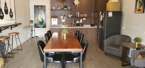 Eine moderne Küche mit einem Holzespeisetisch, schwarzen Stühlen und einem Kühlschrank.