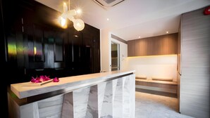 Une cuisine moderne dotée d’un plan de travail en marbre, de luminaires suspendus et d’une banquette intégrée.